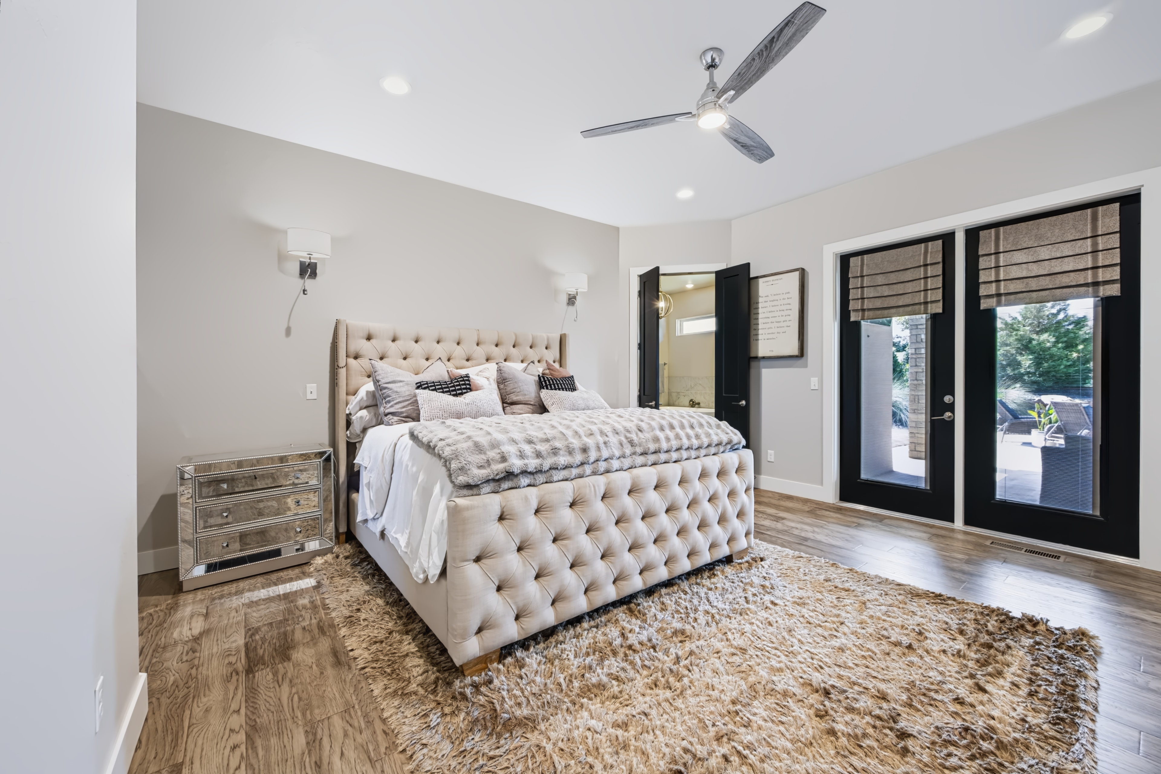Master bedroom with tufted upholstered bed and hardwood floors at 21458 S Sawtooth Cir